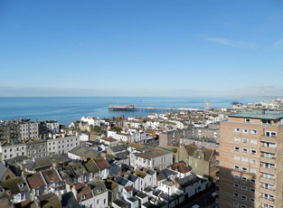 The Brighton skyline, showing many different types of houses and flats, and looking out to the sea in the distance.