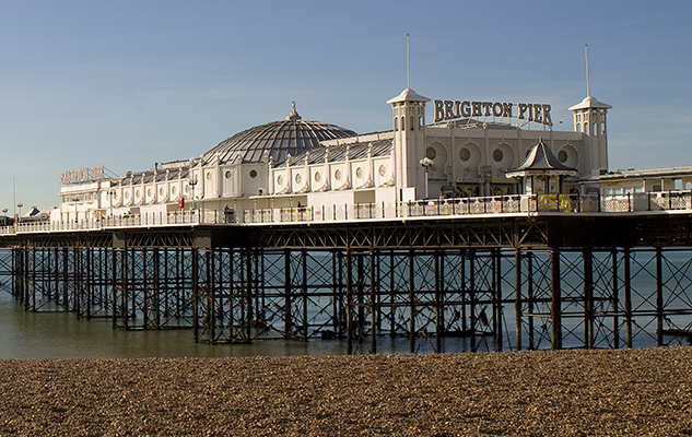 Brighton Pier seen from the left-hand side of the entrance as dusk sets in